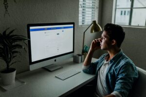 man on desktop computer looking at facebook