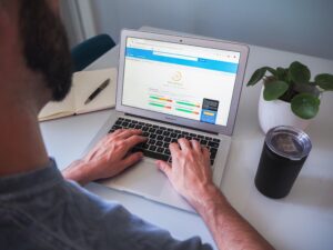 person typing on laptop with analytics on screen