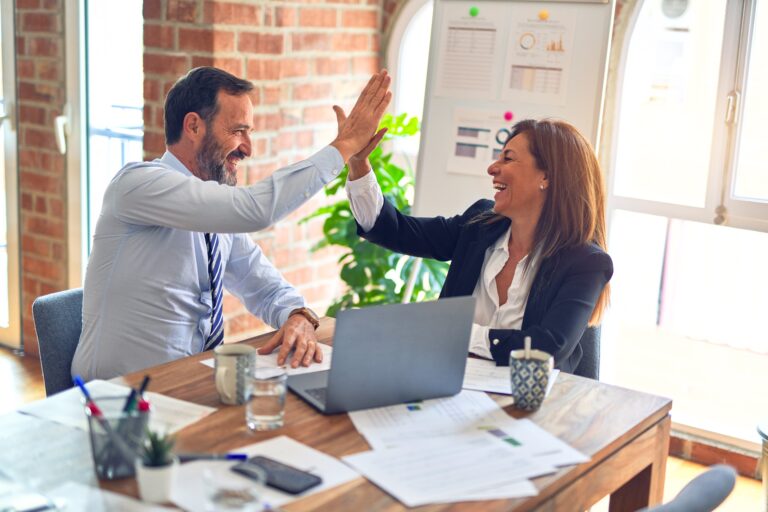 two coworkers high fiving during meeting