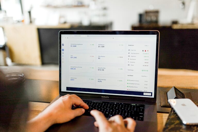 hands on laptop keyboard with data on screen